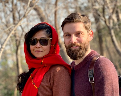 A stock photo of two people looking towards the camera in a wooded area.