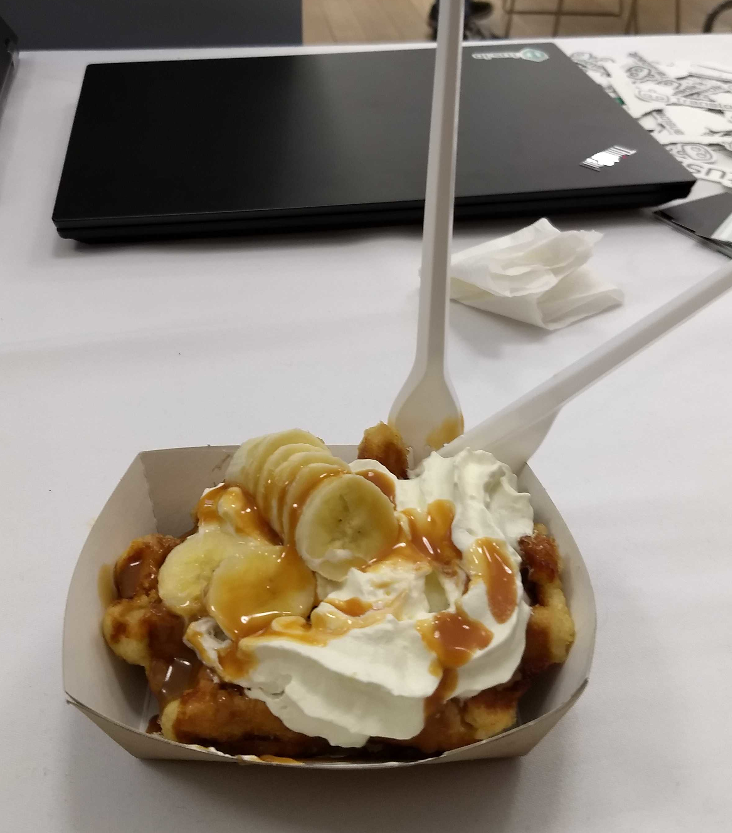 A photo of a waffle with whipped cream and banana